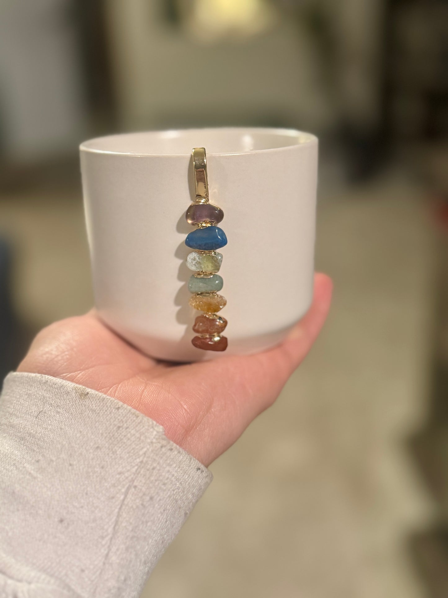 White Ceramic Pot with Aligned Chakra Pendant and Snake Plant